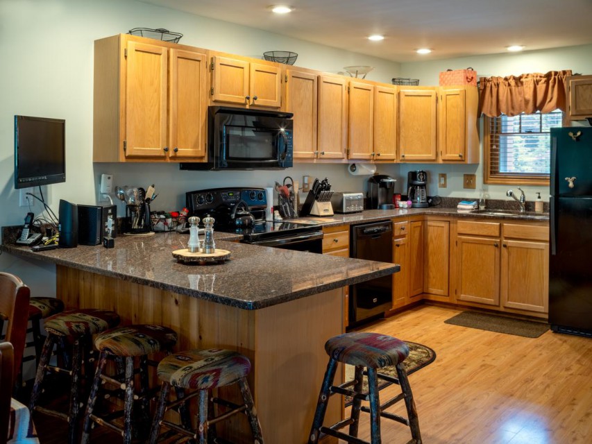 Our very nice open kitchen, with 4 stools and a TV!