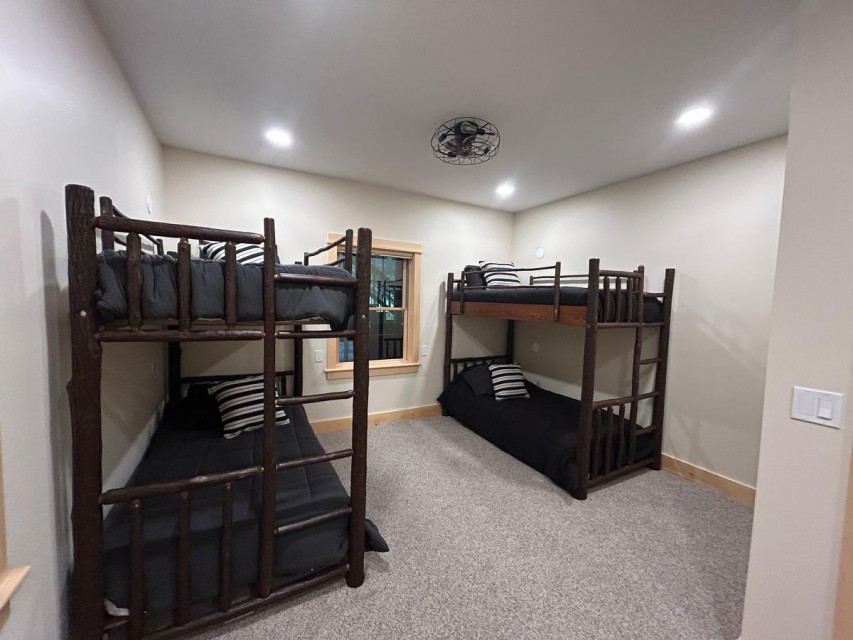 bunk room with four rustic twin beds and ensuite bath