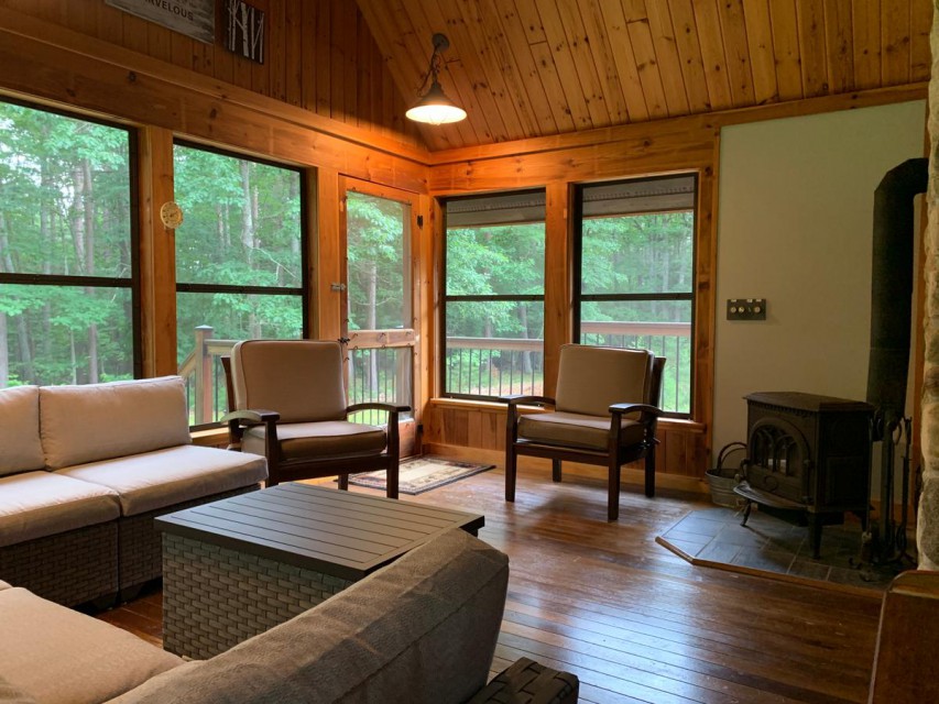 enclosed porch with woodburning stove and comfy seating